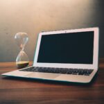 Computador lento: notebook aberto ao lado de uma ampulheta